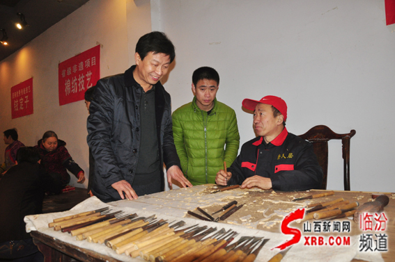 03、臨汾市非物質文化遺產主任任江波（左一）在向制作師傅了解晉作家具制作雕刻技藝